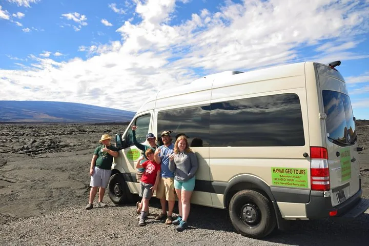 Family posing beside a cream Hawaii Geo Tours van on a broad lava field